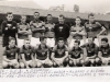 1956 - Caldense x Esportiva, em Poços de Caldas. Em pé, Flávio, Lanza, Nardão, Lelé, Dúsca, Albano e Alemão; agachados, Lori, Faé, Barizon, Lilo Cassini, Benedetti, Valdemar e Tatáu.
